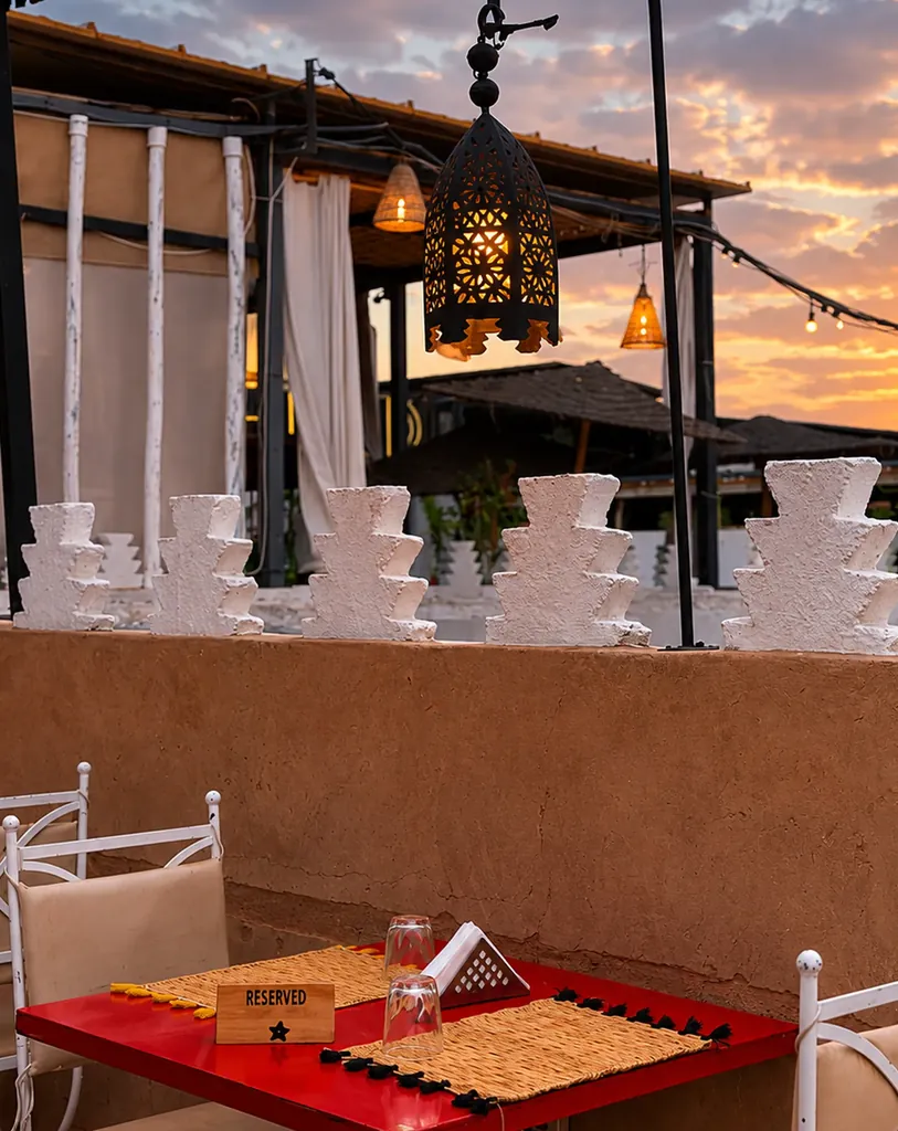 La terrasse de Kui-Zin au coucher du soleil, lanternes allumees au-dessus des tables rouges