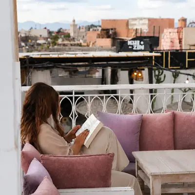 Cliente installee sur une banquette, vue sur les toits de la medina