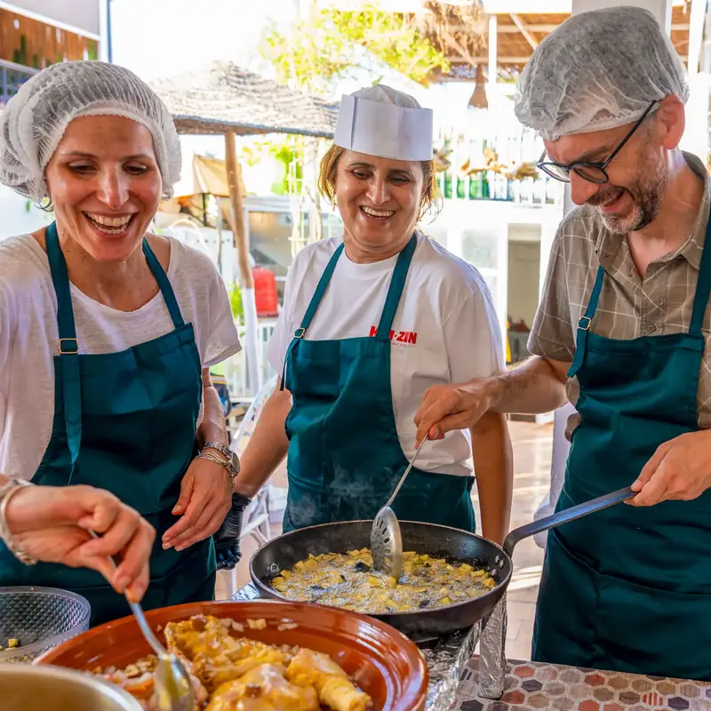 Groupe préparant un tajine pendant un cours de cuisine sur le rooftop de Kui-Zin