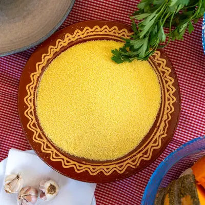 Semoule de couscous dressee dans un plat marocain, entouree de legumes et d'aromates