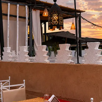 La terrasse de Kui-Zin au coucher du soleil, lanternes allumees au-dessus des tables rouges