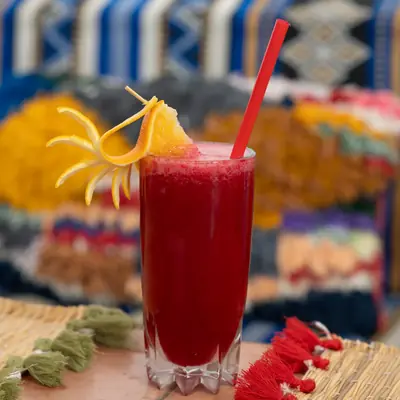 Jus de fruits rouges frais garni d'ecorce d'orange, sur un tapis berbere