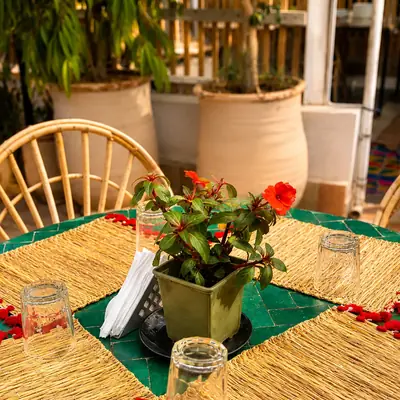 Table dressee sur le zellige vert, fleurs fraiches et sets rouges
