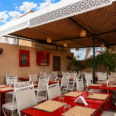 Tables rouges alignees sous la voile blanche de la terrasse de Kui-Zin